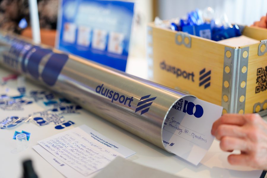 Die Edelstahl-Zeitkapsel mit duisport-Logo liegt auf dem Tisch der Kapsel-Station.